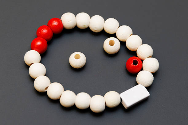 Round wooden beads, painted red and white, arranged in a semicircle on a black background. Ideal for craft, jewelry, or hobby visuals.