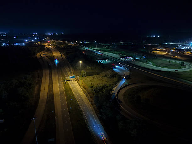 istock Multiple cars speed along a busy highway at night, their headlights illuminating 2242215864