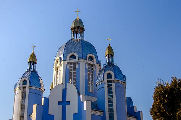 A stunning blue-domed church with golden crosses under a clear sky, showcasing beautiful architectural design.