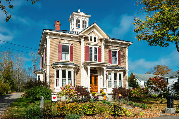 Methuen MA USA Sep 16 2025: A charming Queen Anne style house sits atop a small hill overlooking Pleasant Street across from Methuen City Hall.