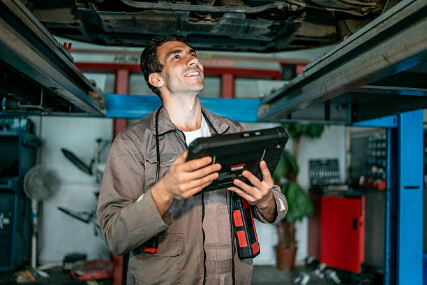 istock Mechanic In Auto Shop Using Tablet Under Lifted Car For Vehicle Diagnostics 2242223682