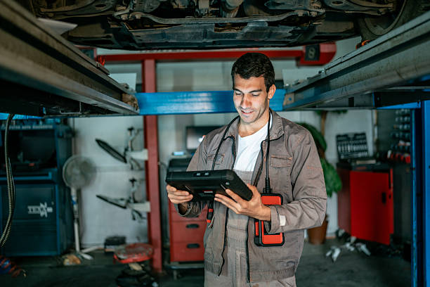 istock Mechanic Using Diagnostic Tablet Under Car In Auto Shop 2242223691