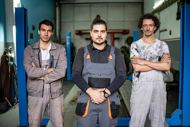 istock Team of Auto Technicians Standing in a Workshop, Confident and Ready to Work Together 2242223795