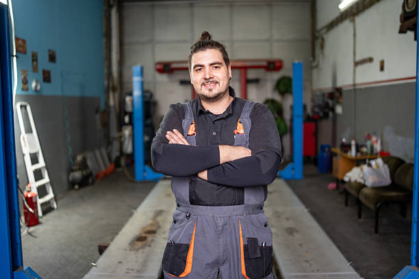 istock Confident Auto Mechanic Stands in Workshop With Arms Crossed, Ready To Work 2242223899