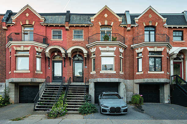 A car is parked in front of a row of townhouses in Montreal, Quebec, Canada on a sunny day.