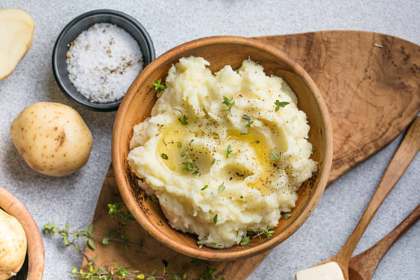 istock Mushed potatoes top view with raw potatoes and spices 2242227411