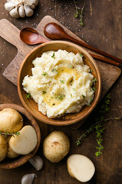 istock Mushed potatoes top view with raw potatoes and spices 2242227420
