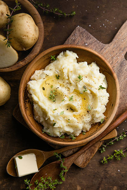 istock Mushed potatoes top view with raw potatoes and spices 2242227421