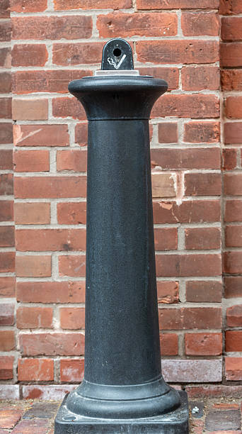 istock Tall  black cigarette street ashtray against red brick wall 2242227647