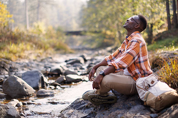 istock Man resting by a river in the forest 2242230834