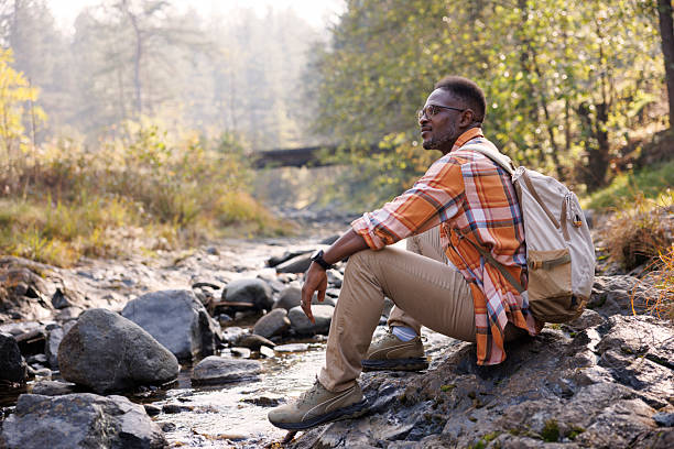 istock Man resting by a river in the forest 2242230987
