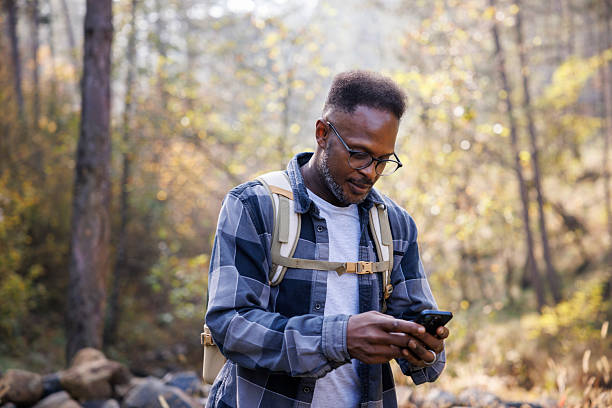 istock Man on hiking adventure checking route on phone 2242231071