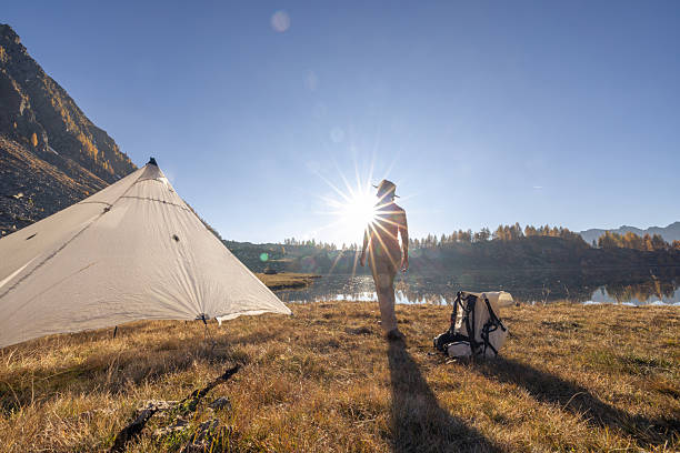 istock Hiker Walking Near Tent by Mountain Lake 2242231793