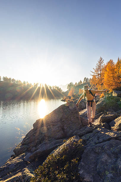 istock Hiker Walking on Rocky Shore at Sunset 2242234671