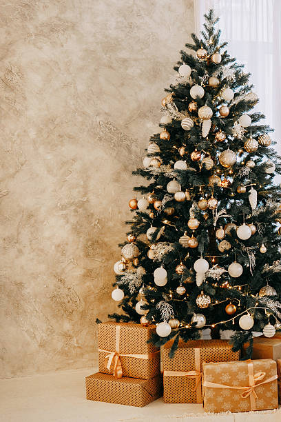 istock Christmas tree decorated with gold and white ornaments, presents underneath for Holiday celebration, festive interior design concept. 2242234677
