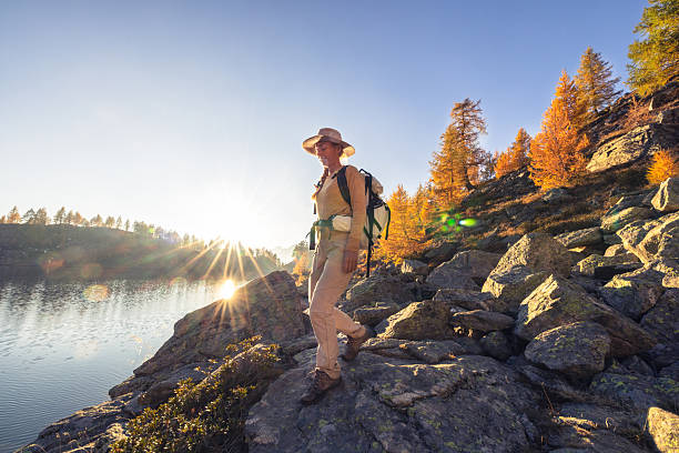 istock Hiker Standing by Lake in Autumn Sunlight 2242234696