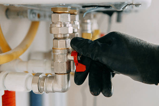 istock Gloved hand adjusts a valve on industrial equipment, showcasing industrial maintenance work. The image highlights the precision and care involved in technical operations. Gas boiler taps. 2242234997
