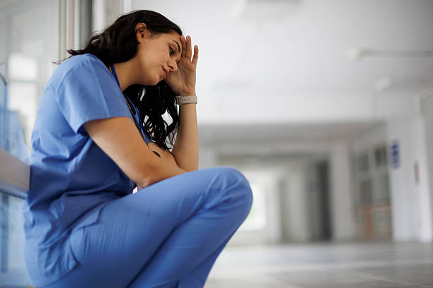 istock Exhausted nurse sitting on the hospital floor after a long shift 2242235340