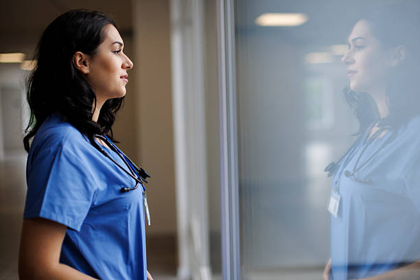 istock Thoughtful healthcare worker standing by window 2242235477