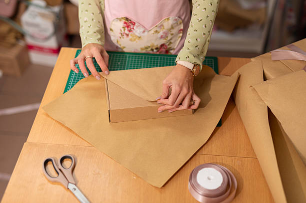istock Woman hands wrapping gift box for small business 2242237078