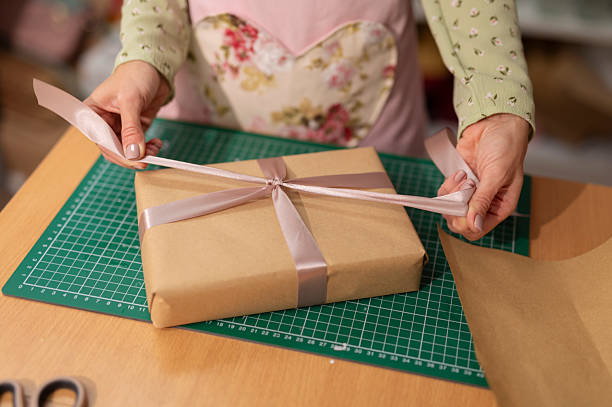 istock Woman tying ribbon on handcrafted present parcel 2242237105