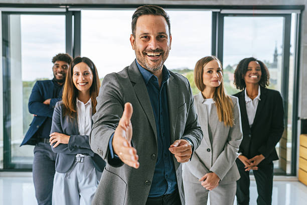 istock Business leader extending hand to diverse professional team 2242238543