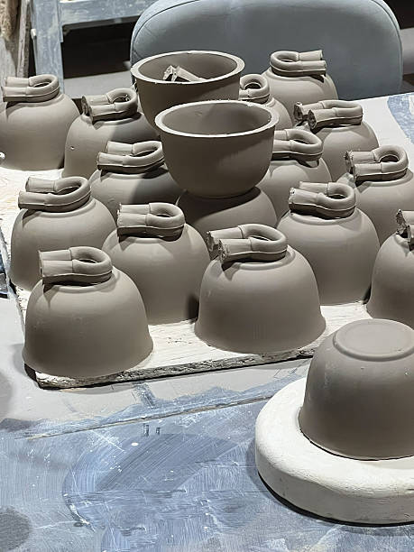 istock Ceramic artisans create clay vessels in a workshop, with multiple pieces in various stages of development on display 2242239137