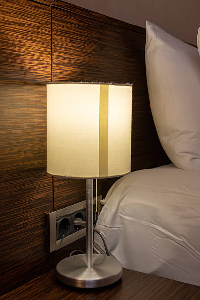 istock Soft light bedside lamp illuminated next to a neatly made bed 2242240897