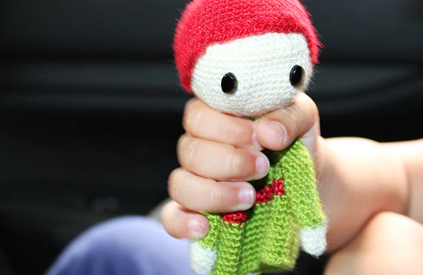 Hand holding an amigurumi doll, a Japanese crocheting technique