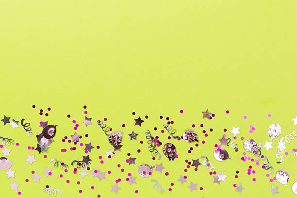 Party pink confetti on color background, top view
