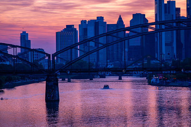 Vibrant urban sunset with river Main and arched bridge, modern Frankfurt am Main skyline, financial district, skyscraper facade, Germany travel, Europe infrastructure, Frankfurt - August 11, 2025