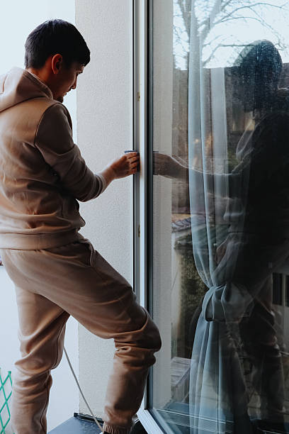 istock One person washes a window frame with a rag on the second floor. 2242250115