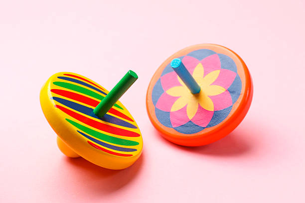 istock Two colorful spinning tops on pink background, closeup 2242259198