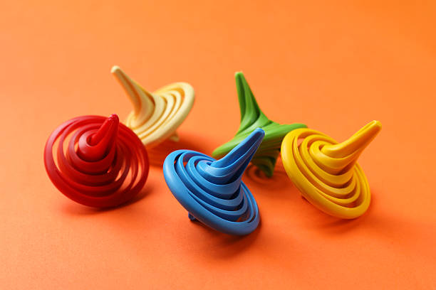 istock Many colorful spinning tops on orange background, closeup 2242259271