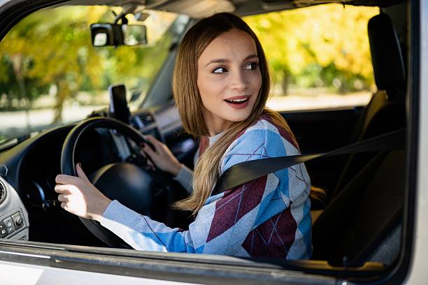 istock Woman looking back while driving car, reversing 2242260431