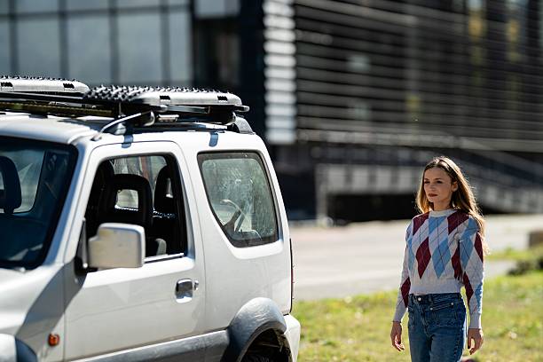 istock Woman standing next to suv in urban setting 2242260504