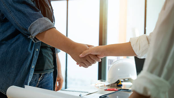 istock Two people shaking hands in a business setting. Scene is professional and friendly. The handshake symbolizes a positive interaction between the two individuals 2242267185