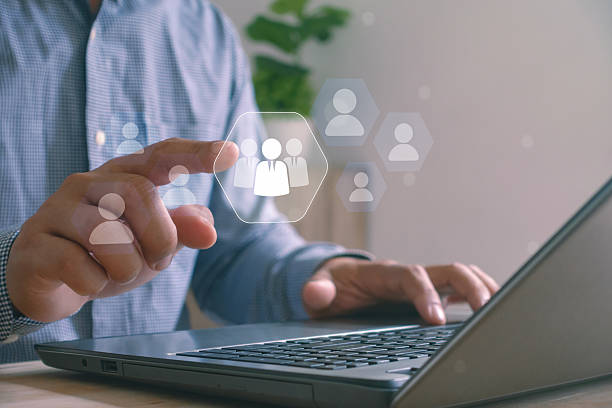 istock Businessman using laptop with virtual interface selecting group of people icon, concept of human resources management, recruitment and digital networking for business technology. 2242272550