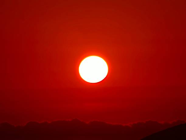 A truly captivating image of the sun beautifully setting, casting a warm, red hue across the vast sky