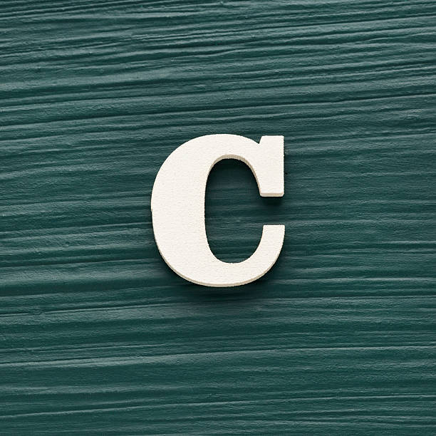 istock Alphabet letter C, white piece on a dark green rustic background 2242276583