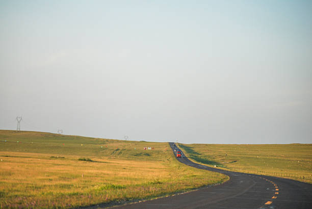 istock Winding road through vast grassland under clear sky 2242276668