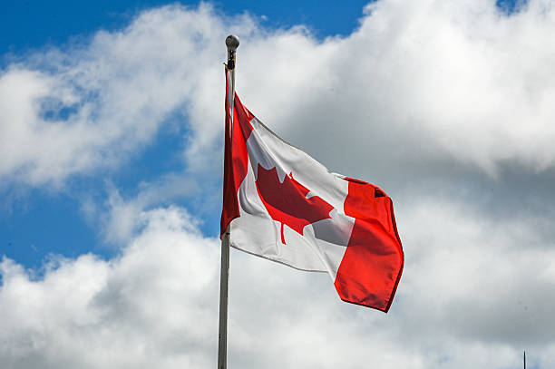 istock Waving canadian flag against sky 2242277527