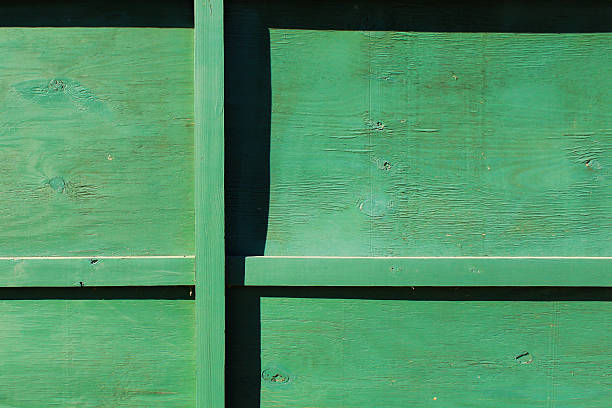 Worn Green Wooden Fence with Shadows and Lines