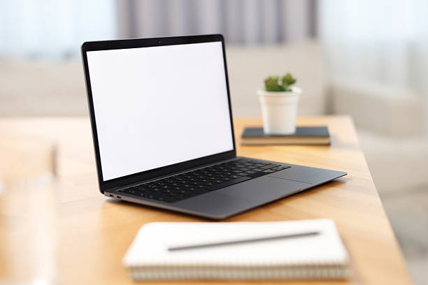 istock Laptop with blank screen on wooden table in room 2242290404