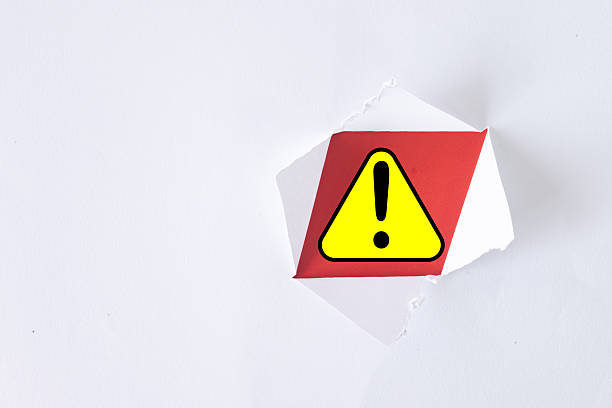 Torn white paper with a yellow warning sign inside, concept of caution, alert, danger, or risk, minimalist design for warning, notification, or hazard symbol on clean white background.