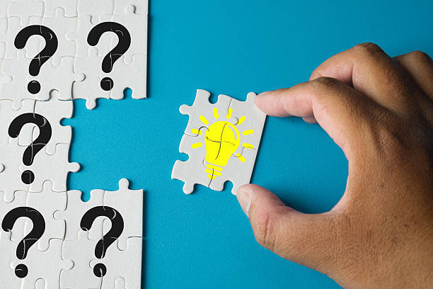 istock Finding the Solution: Hand Placing the Idea (Lightbulb) Puzzle Piece. 2242293226