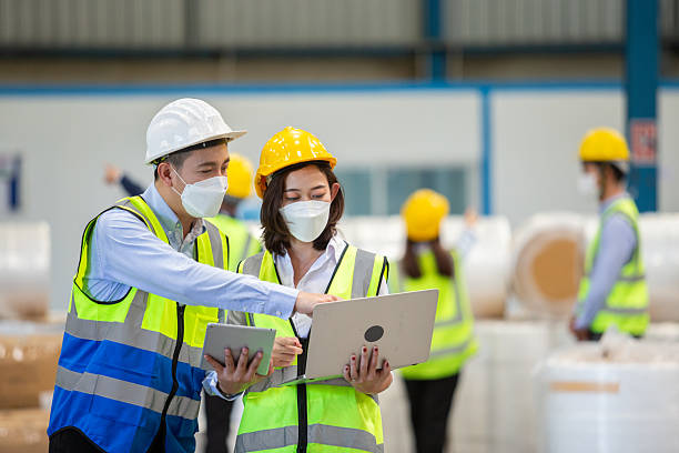 istock Teamwork engineer in uniform wear protection mask brainstorming workshop industrial factory using laptop and tablet. 2242294232