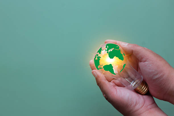 istock Green Energy Idea and Sustainable Innovation Concept. Hands holding Earth lightbulb. 2242294619
