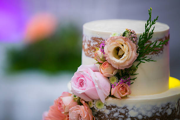 istock Beautiful white wedding cake decorated with flowers close up 2242296782