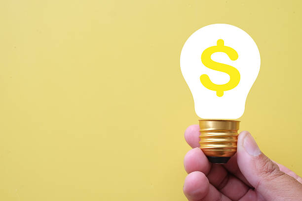 istock Money Making Idea: Hand Holding Lightbulb with Dollar Sign 2242308702